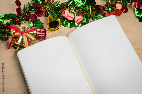 blank notebook on wood table with christmas decorations © paulfourk