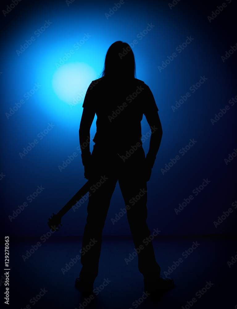 silhouette guitarists of a rock band with guitar on blue background