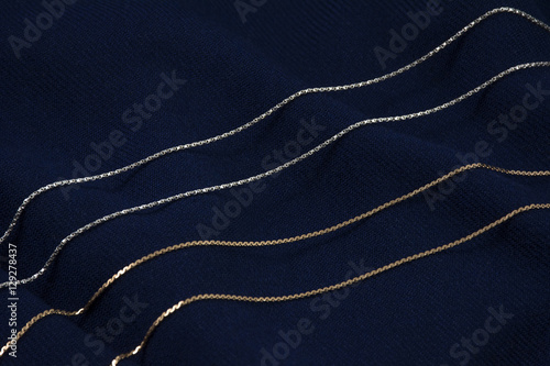 Two golden and silver chains on the deep blue background
