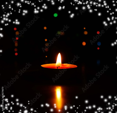 One candle flame light at night with bokeh lights on dark background. Christmas candle