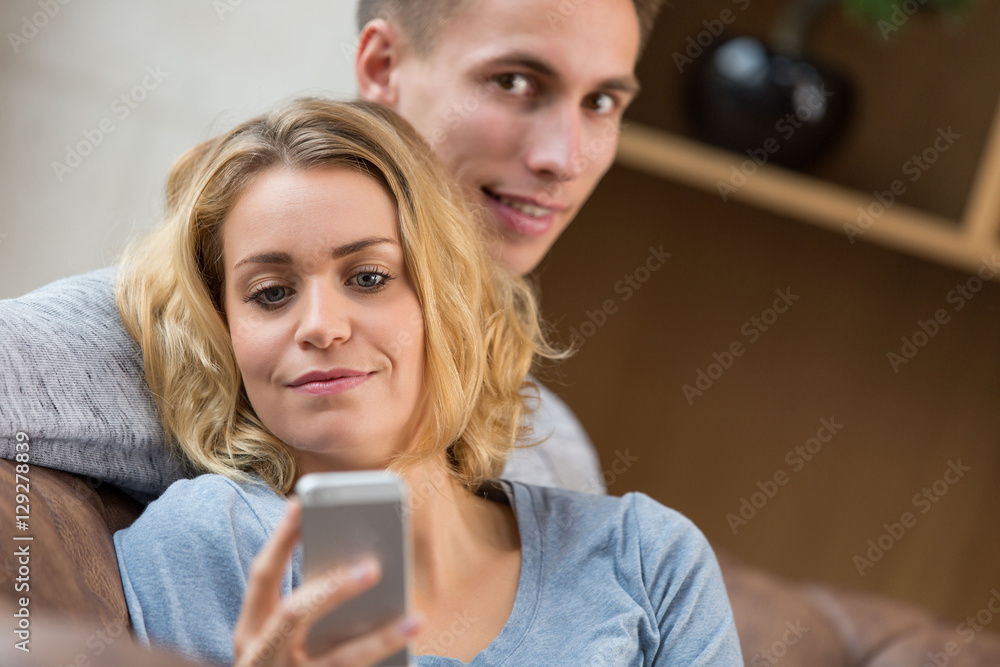 Couple At Home In Lounge Using smartphone Couple At Home In Lounge Using smartphone