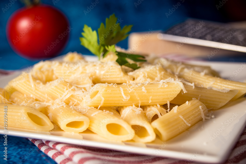 Penne pasta with parmesan cheese on a blue background Penne pasta with parmesan cheese on a blue background