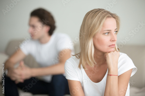 Fototapeta Serious sad woman thinking over a problem, man aside, meeting therapist, poor ch