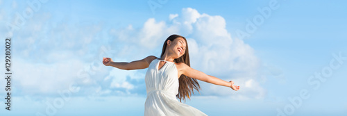 Obraz na płótnie Serene free Asian woman with open arms in freedom or success on sky clouds panorama horizontal banner crop for copyspace