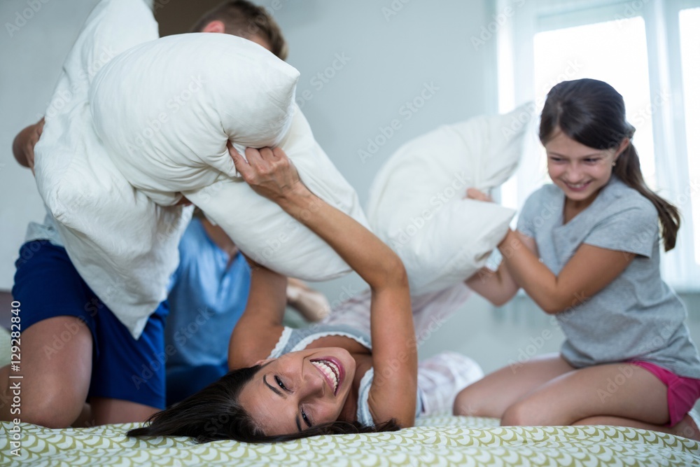Family having pillow fight in bedroom Family having pillow fight in bedroom