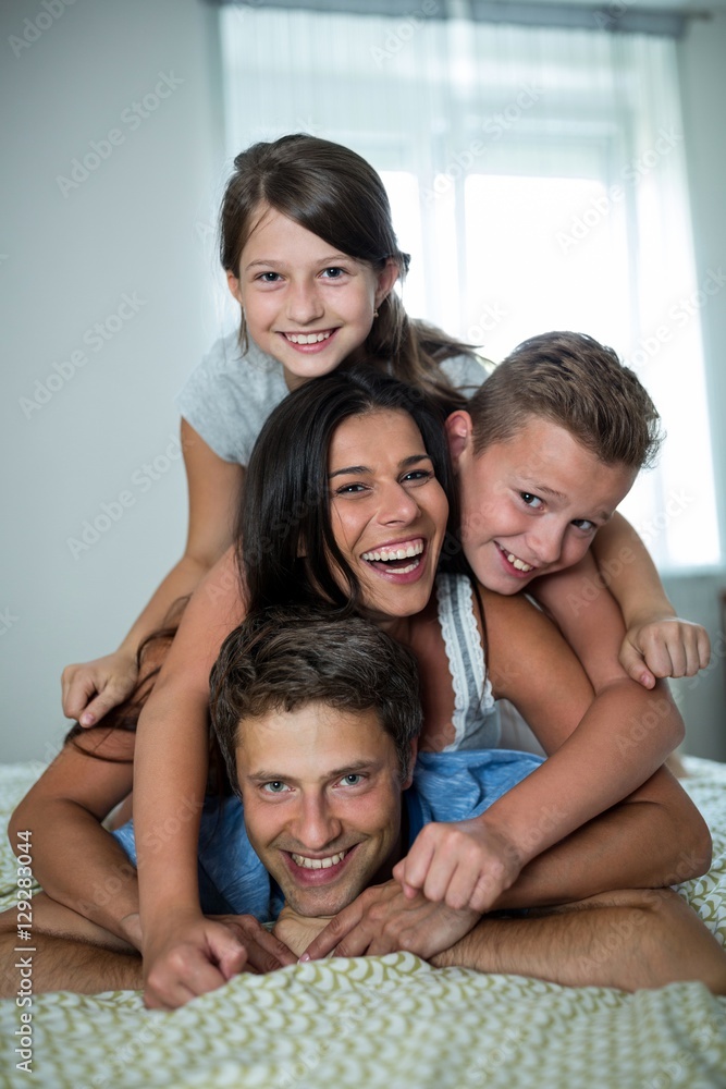 Happy family having fun in bedroom