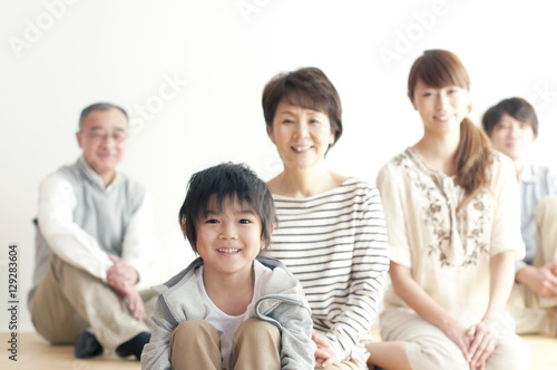 床に座り微笑む3世代家族