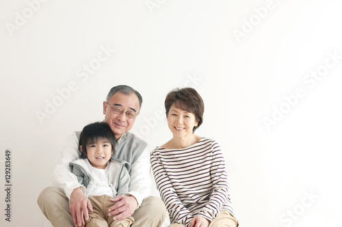 床に座り微笑む孫と祖父母
