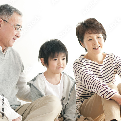 床に座り微笑む孫と祖父母