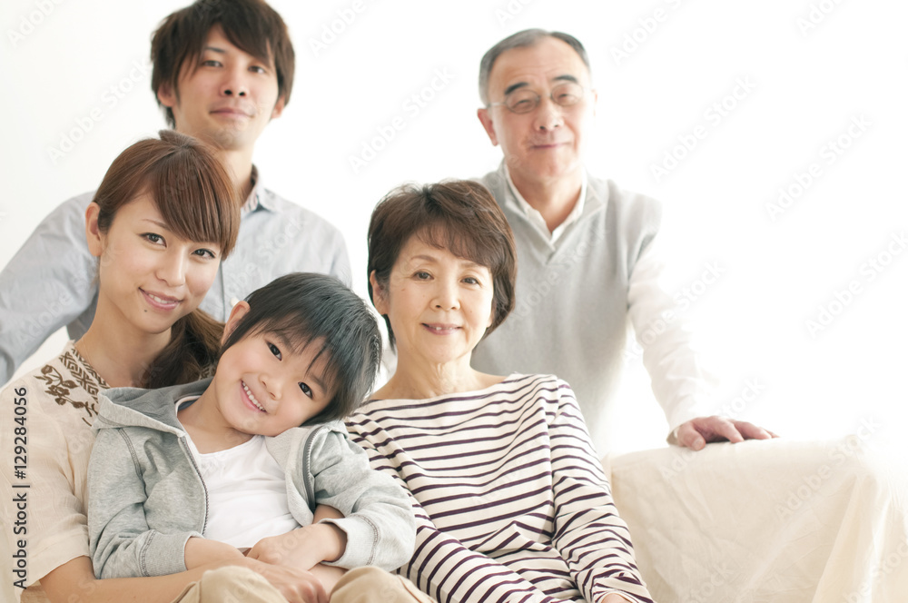 ソファーに座り微笑む3世代家族