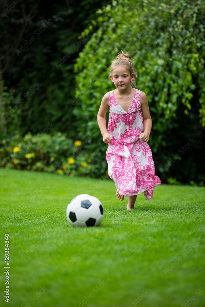Girl playing with football in park Girl playing with football in park