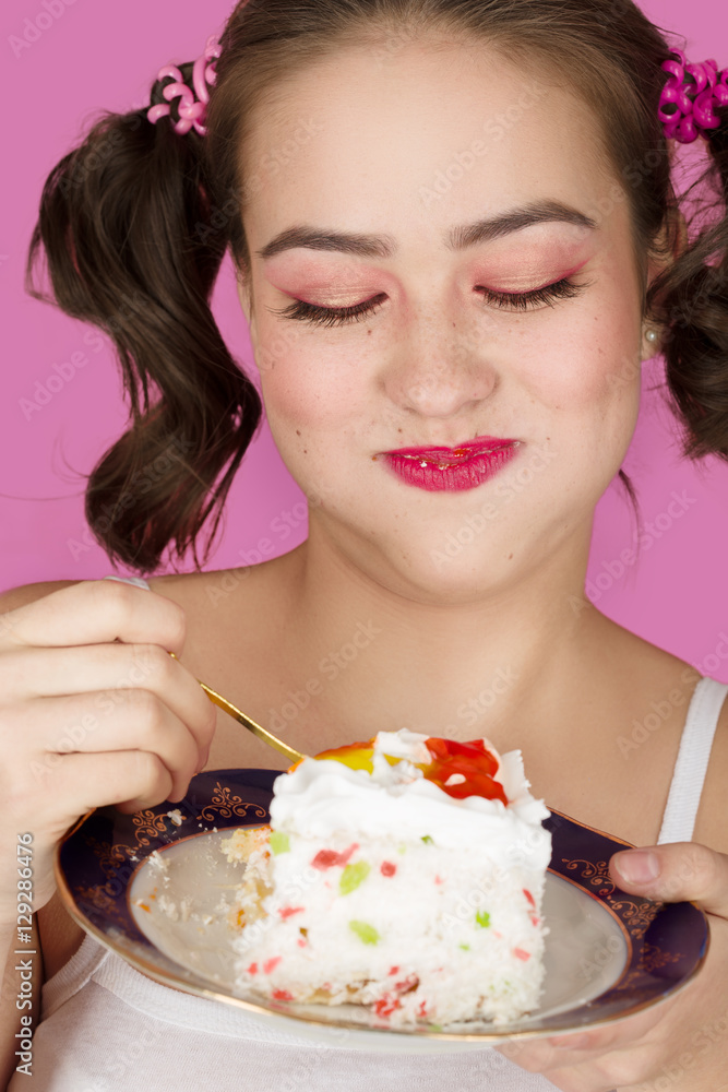 happy pretty girl eats sweet dessert on pink background happy pretty girl eats sweet dessert on pink background