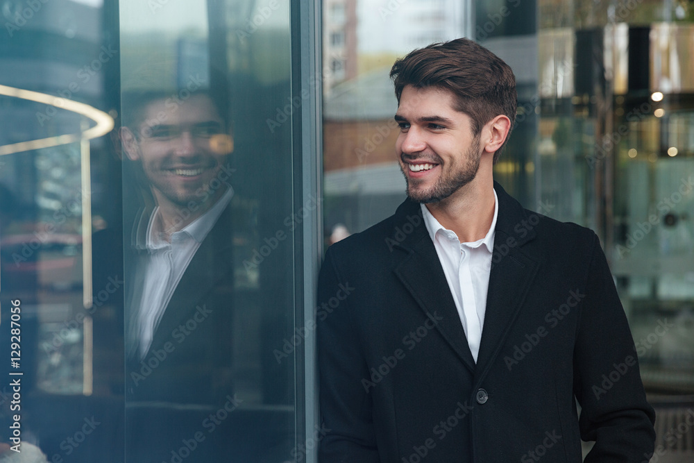 Happy businessman standing near business center and look aside. Happy businessman standing near business center and look aside.