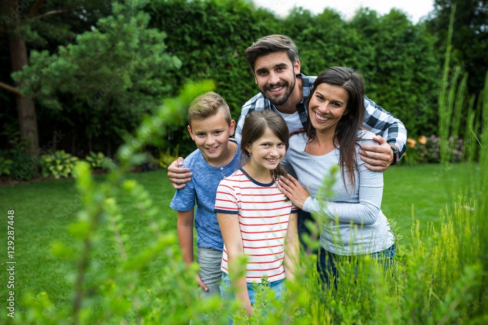 Fototapeta premium Happy family standing on grass in park on a sunny day
