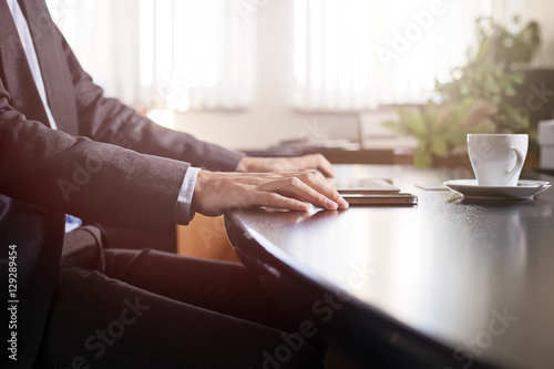 business man hands on a table with tablet, phone and cup of coff