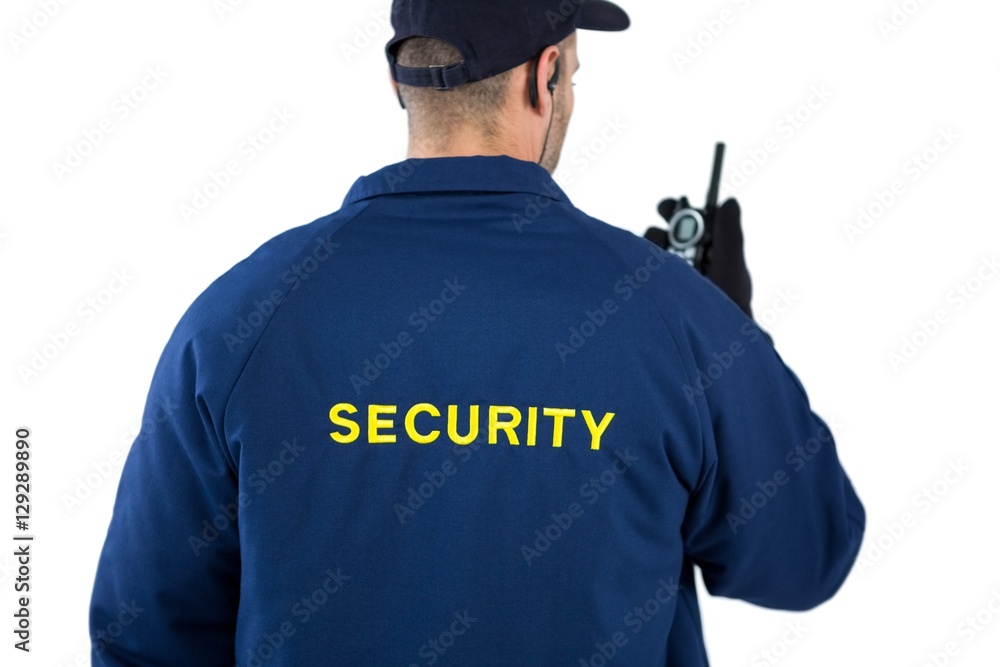 Rear view of security officer talking on walkie-talkie
