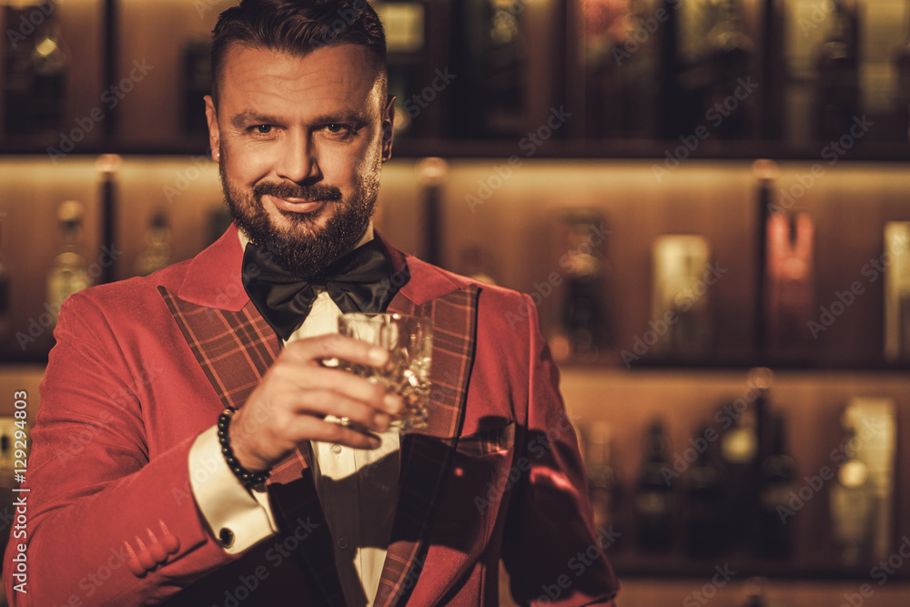 Wall Mural Extravagant stylish man with whisky glass in gentleman club