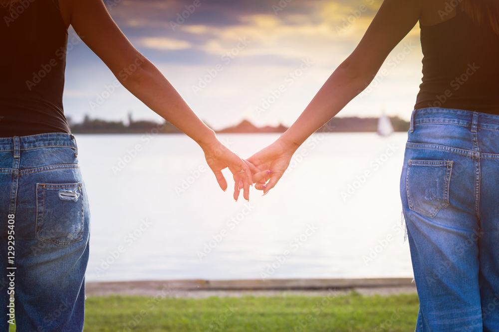 Two woman holding their hands in summer sunny day Two woman holding their hands in summer sunny day