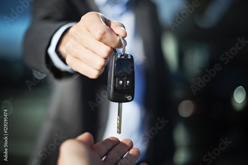 man hand in suit giving car keys 