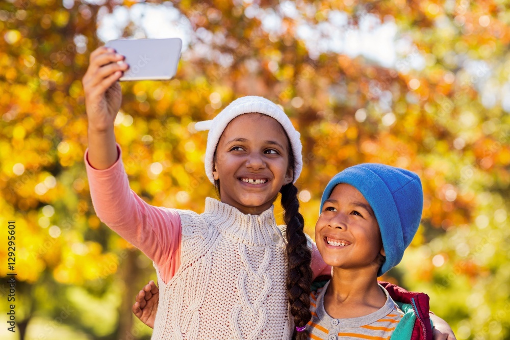Smiling siblings taking selfie at park Smiling siblings taking selfie at park