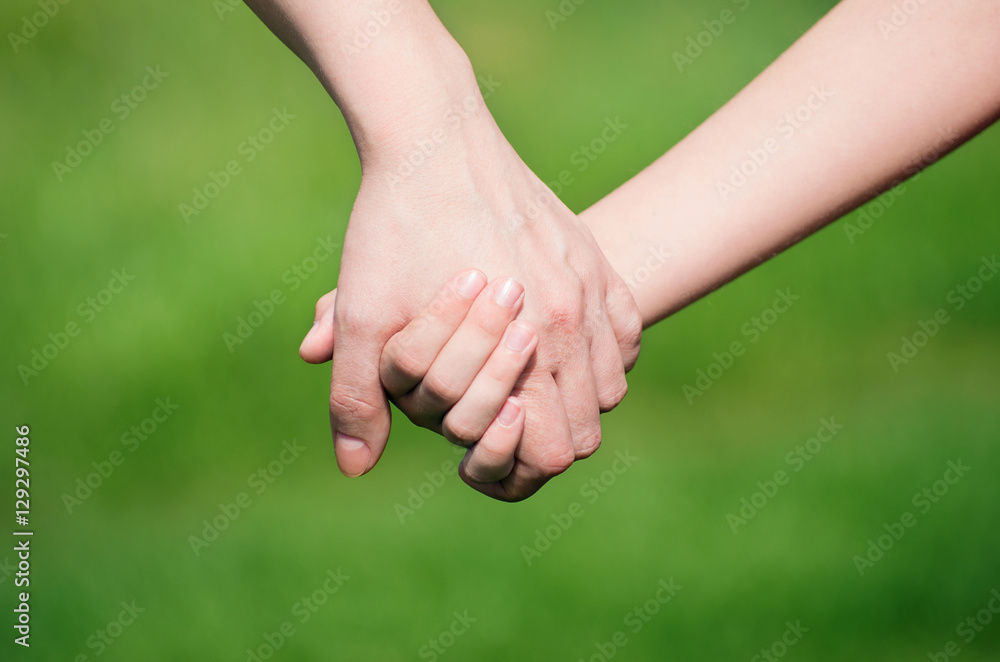 Mother holding a hand of his son in summer day outdoors Mother holding a hand of his son in summer day outdoors