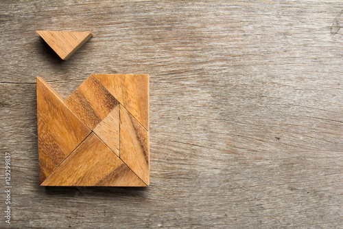 Wooden tangram with one piece is wait to fulfill the square shap photo
