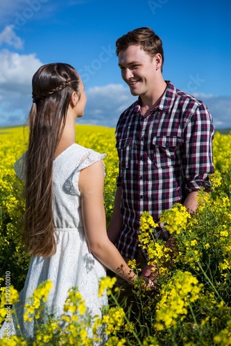 Romantic couple looking at each other in mustard field