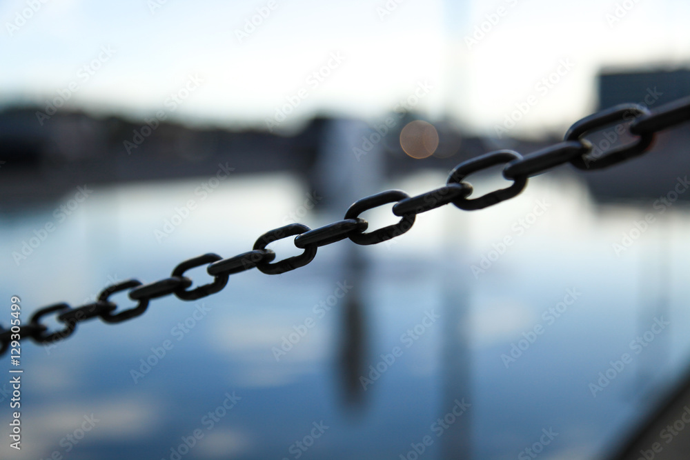 Iron chain detail, city in the background, selective focus, take