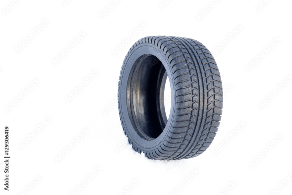 Black rubber tire rolling on the soft, fresh snow in the sunny day. White background. Seasonal tire change. Black rubber tire rolling on the soft, fresh snow in the sunny day. White background. Seasonal tire change.