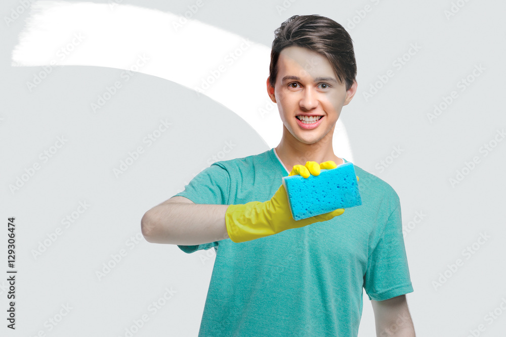 Housekeeping concept. Studio portrait of handsome young man in gloves cleaning glass with wisp. Isolated on white. Housekeeping concept. Studio portrait of handsome young man in gloves cleaning glass with wisp. Isolated on white.
