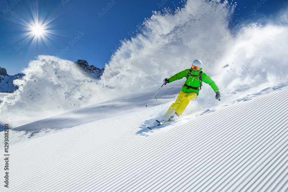 Skier skiing downhill in high mountains