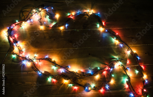 Christmas background with lights and free text space. Christmas lights border. Glowing colorful Christmas lights on black background. New Year. Christmas. Decor. Garland.