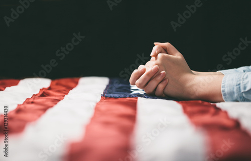 Foto Hands praying over USA flag