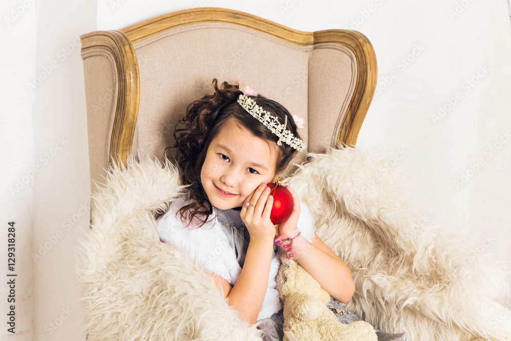Fototapeta premium Girl holding christmas red ball to decorate christmas tree