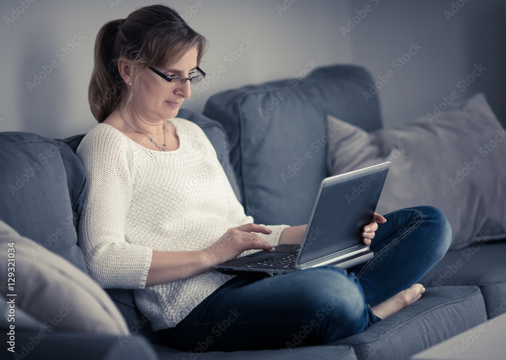 Middle-aged woman using laptop at home Middle-aged woman using laptop at home