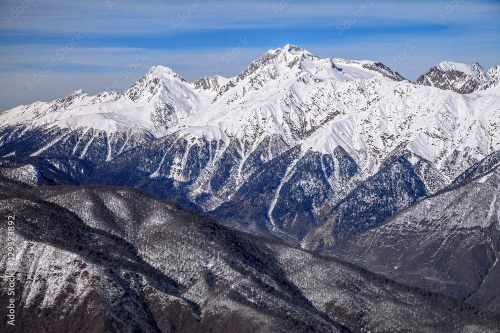 Beautiful mountain scenic winter landscape of the Main Caucasian ridge with snowy peaks and blue sky