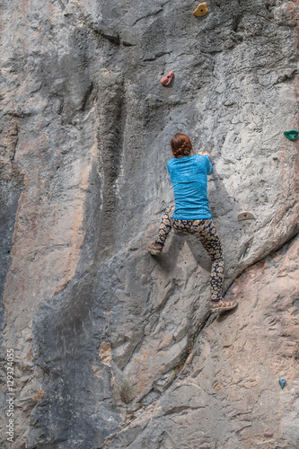 Young girl climbing up the rock in Turkey