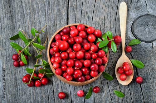 Red lingonberry in wooden bowl photo