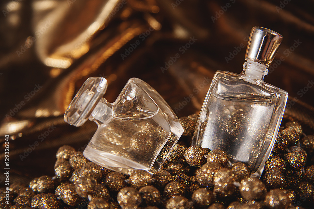 Bottle of woman perfume on gold background. - obrazy, fototapety, plakaty 