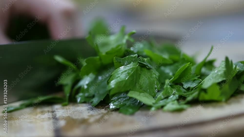 chef cutting parsley on a wooden board. close up chef cutting parsley on a wooden board. close up