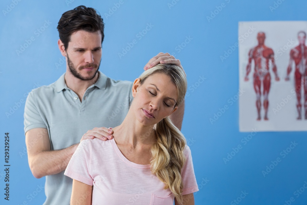 Physiotherapist stretching neck of a female patient Physiotherapist stretching neck of a female patient