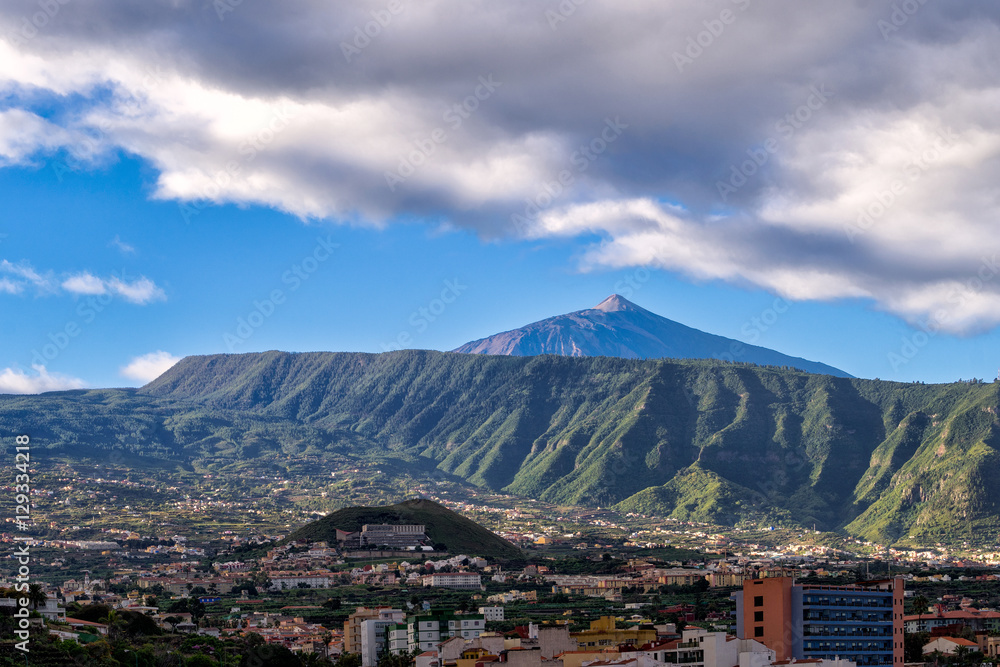 Scenic view of monumental volcano Mount Teide with Puerto Cruz city in a front, Tenerife, Canary Islands, Spain.