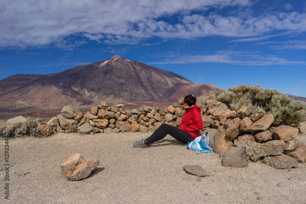 Obraz premium Young female hiker is enjoying view of Mount Teide volcano. Tenerife, Canary Islands, Spain.