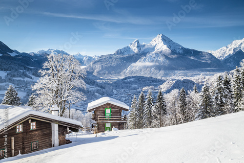 Winter wonderland mountain scenery in the Alps with traditional farmhouses