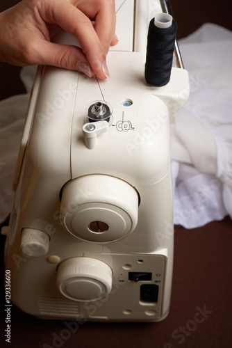 Woman threading on sewing machine