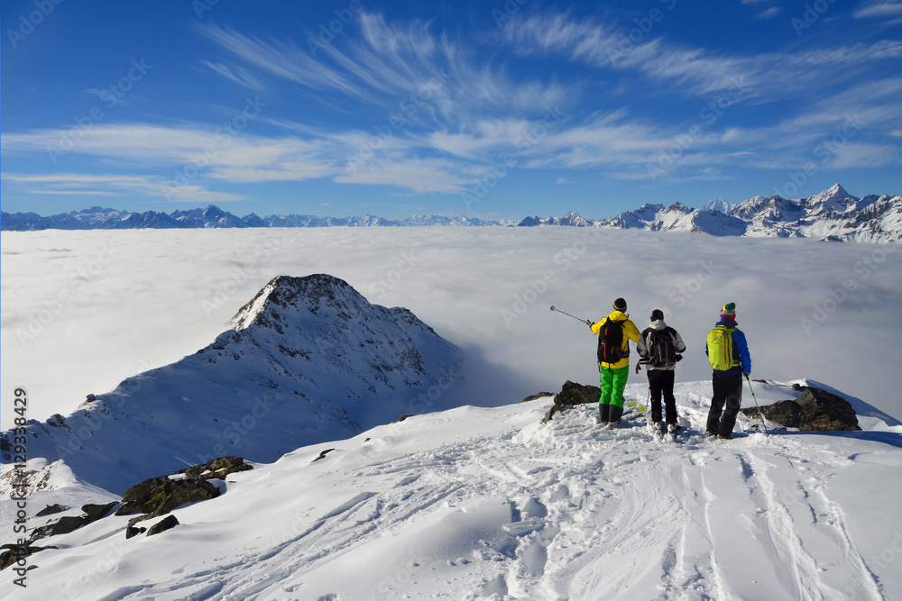 Scialpinisti con mare di nuvole sullo sfondo