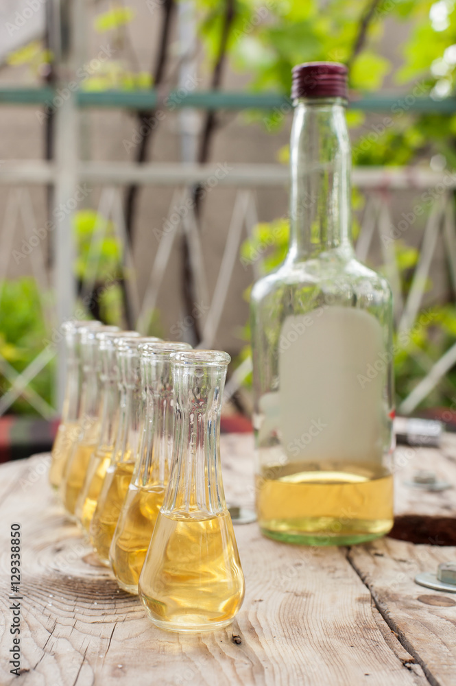 Bottle of plum brandy with small glasses on wooden table Bottle of plum brandy with small glasses on wooden table