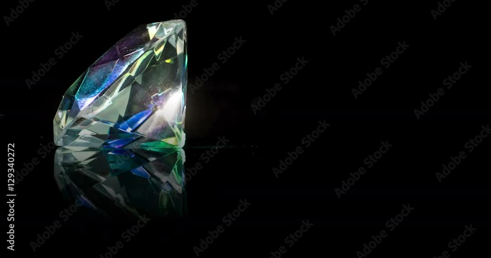 Colorful gemstones rotating on black background with reflection Colorful gemstones rotating on black background with reflection