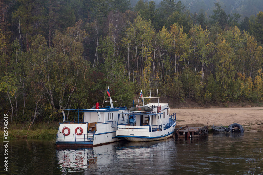 Two boats on the pier near the forest. Lake Baikal. Buryatia. Russia. Two boats on the pier near the forest. Lake Baikal. Buryatia. Russia.