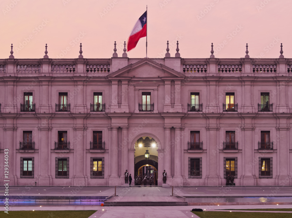 Naklejka premium Chile, Santiago, Twilight view of La Moneda Palace from the Plaza de la Ciudadania.